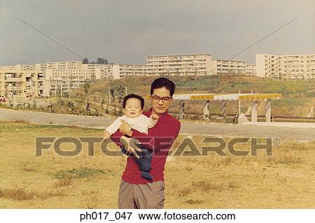 Stock Photo - Father carrying baby boy. Fotosearch