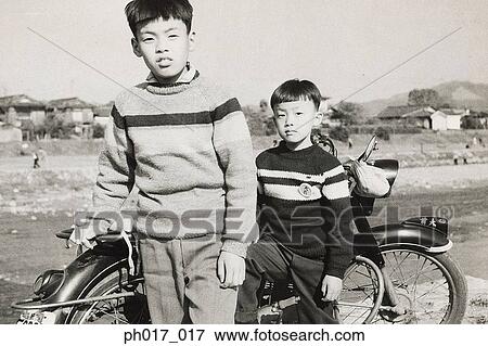 Stock Photo - Two brothers and motorcycle. Fotosearch