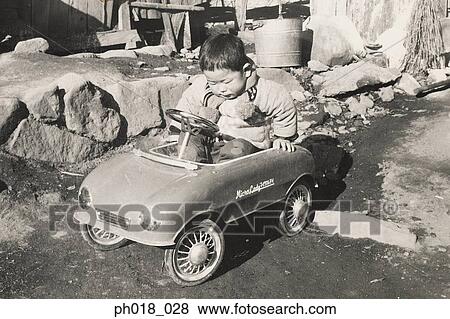 Stock Photo - Baby boy in a toy car ride. Fotosearch