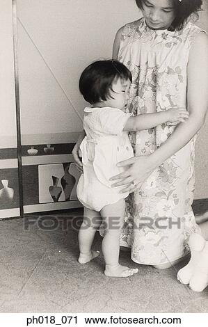 Stock Image - Baby girl hugging mother. Fotosearch