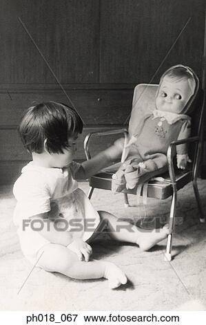 Baby girl playing with doll View Large Photo Image Stock Photo - Baby girl playing with doll. Fotosearch
