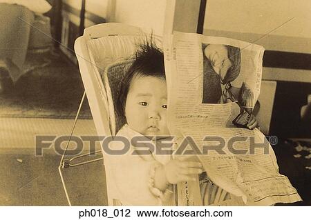 Baby holding newspaper View Large Photo Image Stock Image - Baby holding newspaper. Fotosearch