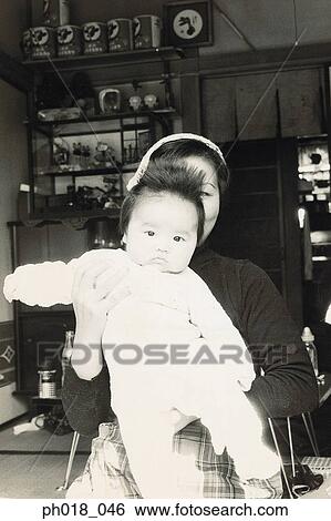 Mother carrying a baby girl View Large Photo Image Stock Photograph - Mother carrying a baby girl. Fotosearch
