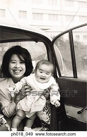 Mother carrying baby girl in the car View Large Photo Image Stock Photo - Mother carrying baby girl in the car. Fotosearch