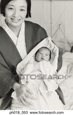 Stock Image - Mother in traditional Japanese costume carrying a baby. Fotosearch