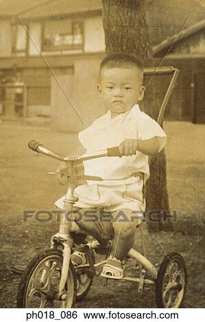 Portrait of a young boy in a tricycle View Large Photo Image Stock Photograph - Portrait of a young boy in a tricycle. Fotosearch