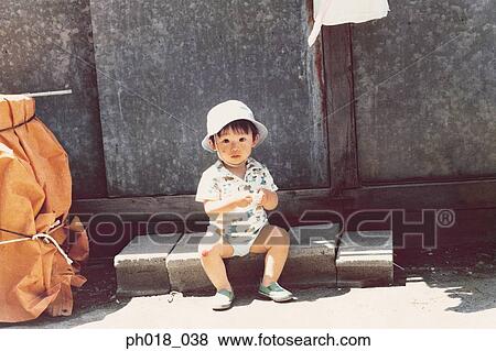 Portrait of a young boy sitting in the shade View Large Photo Image Stock Photo - Portrait of a young boy sitting in the shade. Fotosearch