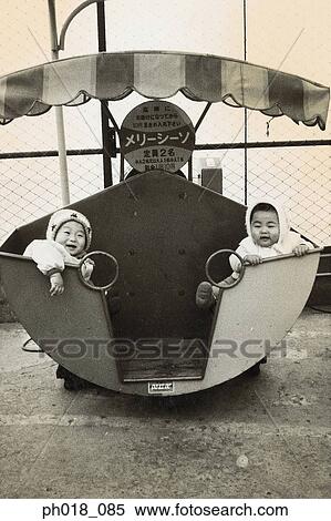 Portrait of twin babies in a amusement ride View Large Photo Image Stock Photography - Portrait of twin babies in a amusement ride. Fotosearch