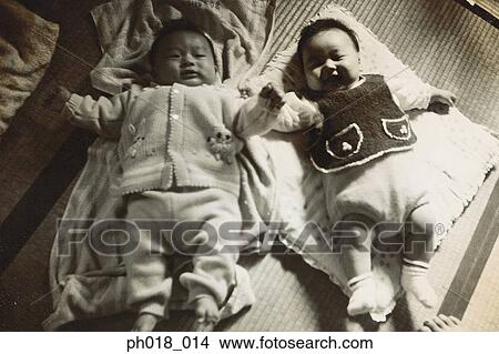 Twin babies lying on mattress View Large Photo Image Picture - Twin babies lying on mattress. Fotosearch