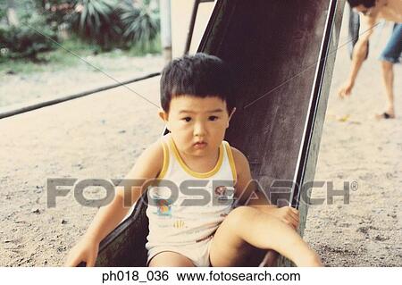 Stock Photograph - Young boy playing in the playground. Fotosearch