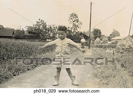 Young boy standing in the middle of a pathway View Large Photo Image Stock Photo - Young boy standing in the middle of a pathway. Fotosearch