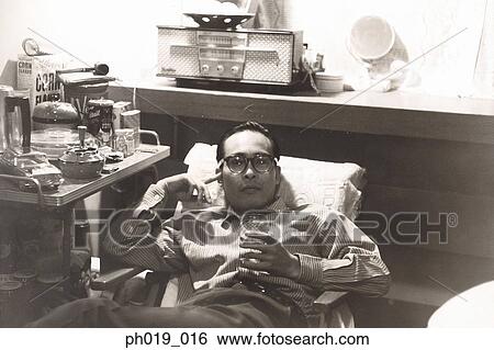 Stock Photograph - Asian man resting with a glass on his hand. Fotosearch