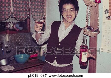 Stock Photo - Man holding a bottle of red wine and a glass. Fotosearch