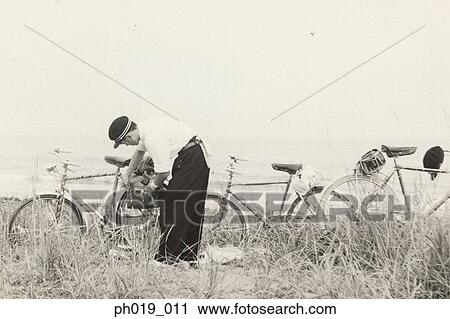 Stock Image - Man locking a bicycle. Fotosearch