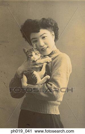 Portrait of an Asian woman carrying a cat View Large Photo Image Stock Image - Portrait of an Asian woman carrying a cat. Fotosearch