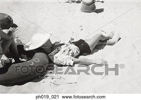 Stock Image - Woman lying on the beach. Fotosearch