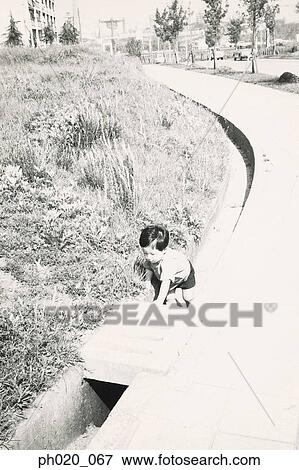 Boy playing in drainage View Large Photo Image Stock Photo - Boy playing in drainage. Fotosearch