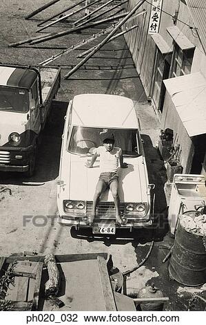 Stock Image - Boy sitting on car. Fotosearch