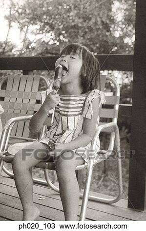 Stock Image - Girl eating snack at balcony. Fotosearch