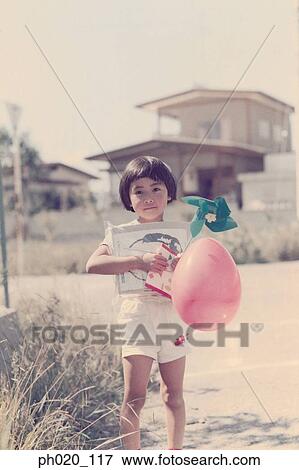 Girl holding toys at the road side View Large Photo Image Stock Photo - Girl holding toys at the road side. Fotosearch