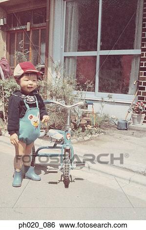 Portrait of a boy and tricycle View Large Photo Image Stock Photograph - Portrait of a boy and tricycle. Fotosearch