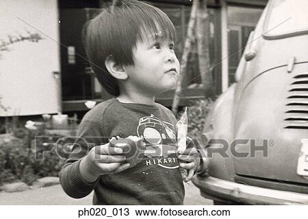 Stock Image - Portrait of a boy holding a bun. Fotosearch