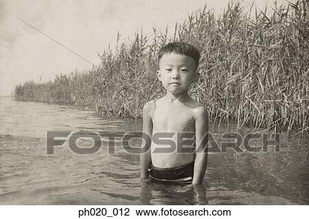 Stock Image - Portrait of a boy in river. Fotosearch