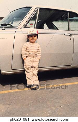 Portrait of a boy leaning against car View Large Photo Image Stock Image - Portrait of a boy leaning against car. Fotosearch