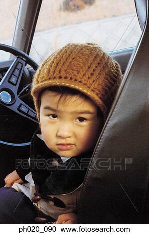 Stock Image - Portrait of a boy sitting on driver's seat. Fotosearch