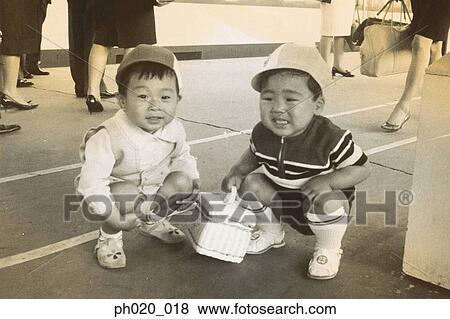 Stock Photo - Two boys squatting in the middle of passage way. Fotosearch
