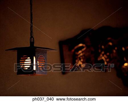 Stock Image - A hanging and lighted lantern. Fotosearch