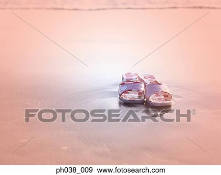 Stock Photo - Pair of sandals on beach. Fotosearch