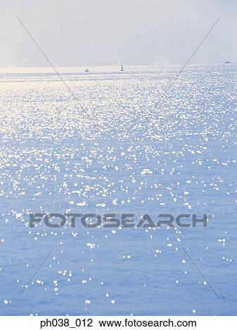 Stock Image - Surface of sea water and reflection of sunlight. Fotosearch