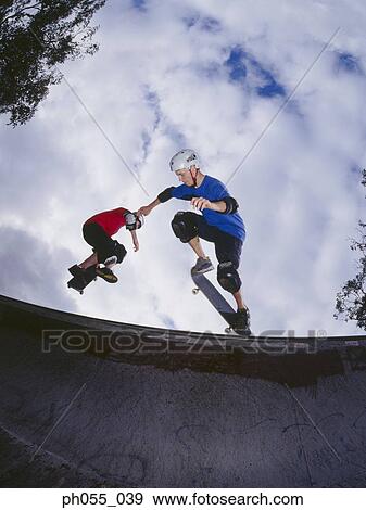 Two young men skateboarding on ramp View Large Photo Image Stock Photo - Two young men skateboarding on ramp . Fotosearch