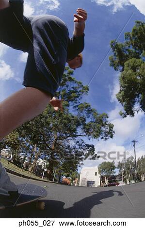 Young man skateboarding down the street View Large Photo Image Stock Photo - Young man skateboarding down the street. Fotosearch
