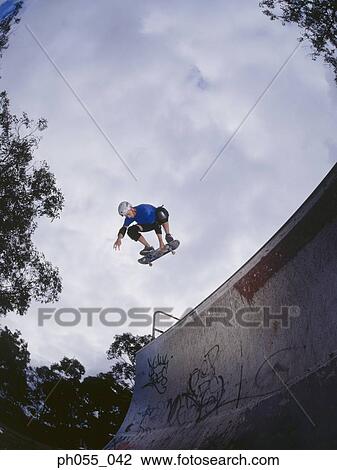 Stock Image - Young man skateboarding on ramp . Fotosearch