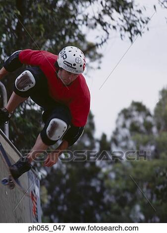 Stock Photo - Young man skateboarding on ramp . Fotosearch