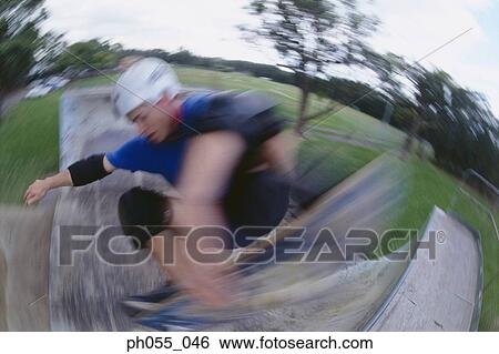 Stock Photograph - Young man skateboarding on ramp . Fotosearch