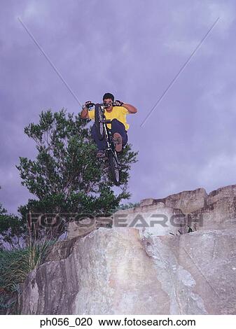 Stock Image - BMX bicyclist in midair, underneath view . Fotosearch