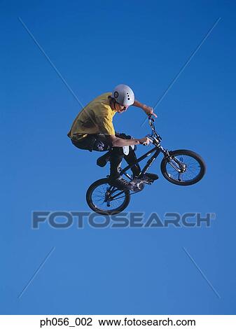 Male BMX stunt rider in mid-jump View Large Photo Image Stock Image - Male BMX stunt rider in mid-jump . Fotosearch
