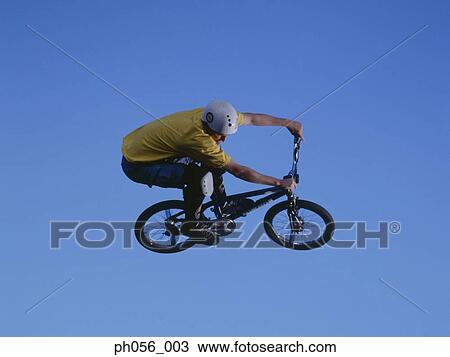 Male BMX stunt rider in mid-jump View Large Photo Image Stock Image - Male BMX stunt rider in mid-jump . Fotosearch