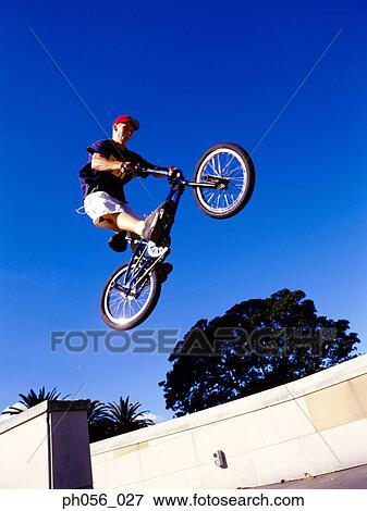 Male BMX stunt rider in mid-jump View Large Photo Image Stock Photo - Male BMX stunt rider in mid-jump. Fotosearch