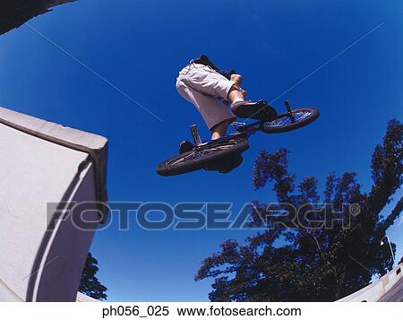 Male BMX stunt rider in mid-jump View Large Photo Image Stock Photography - Male BMX stunt rider in mid-jump . Fotosearch