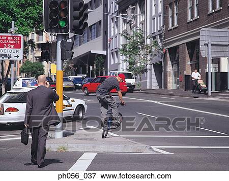 Stock Photo - Young man on bike, at the junction. Fotosearch