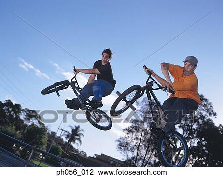 Young men in mid-jump over railing View Large Photo Image Stock Image - Young men in mid-jump over railing. Fotosearch