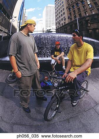 Young men resting on BMX on pavement View Large Photo Image Stock Photography - Young men resting on BMX on pavement. Fotosearch