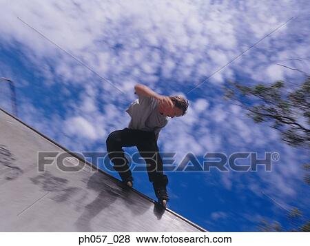 In-line skater performing stunt in mid-air View Large Photo Image Stock Photo - In-line skater performing stunt in mid-air . Fotosearch