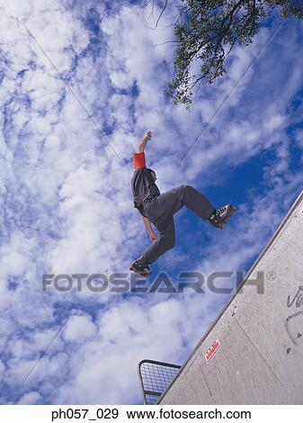 In-line skater performing stunt in mid-air View Large Photo Image Stock Photo - In-line skater performing stunt in mid-air . Fotosearch