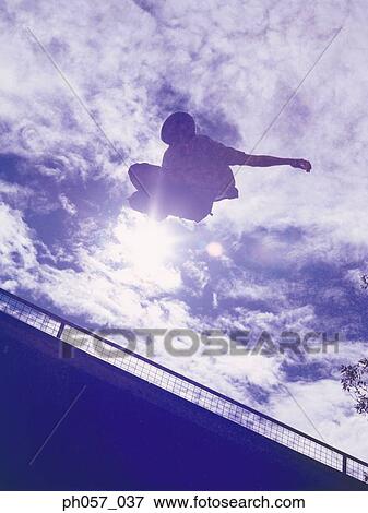 In-line skater performing stunt in mid-air View Large Photo Image Stock Photo - In-line skater performing stunt in mid-air . Fotosearch
