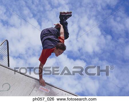 Stock Photograph - In-line skater performing stunt in mid-air . Fotosearch